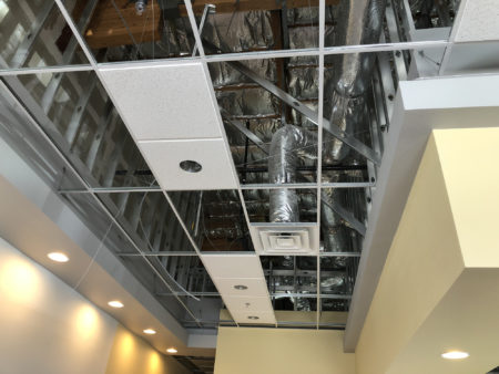 Commercial HVAC system behind an uncovered acoustic ceiling